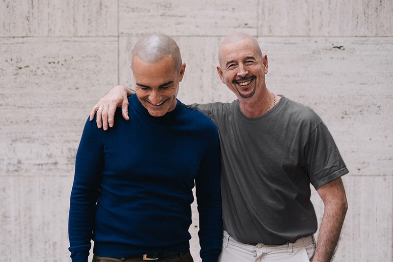 A picture of two bald men looking happy together