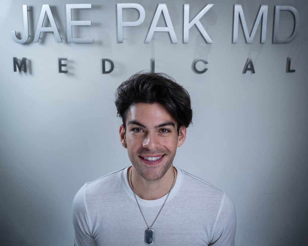 An image of a Twitch Streamer smiling in a photo after his Hair Transplant from Dr. Jae Pak